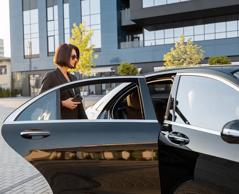 Business woman getting in luxury car